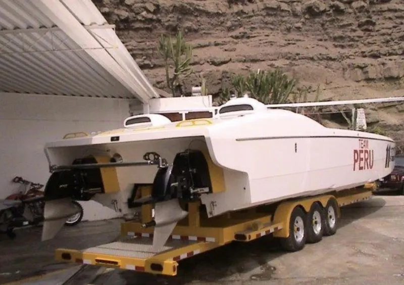 The Image of 2006 MTI 44 powerboat on a trailer, labeled Team Peru, parked in a covered area. - 0
