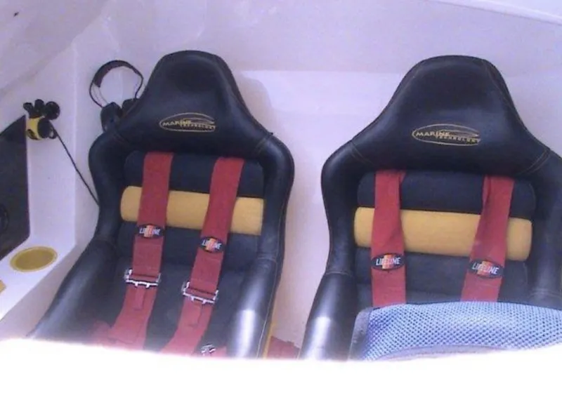 Slide: The Image of 2006 MTI 44 boat interior with two black racing seats and red harnesses. - 6