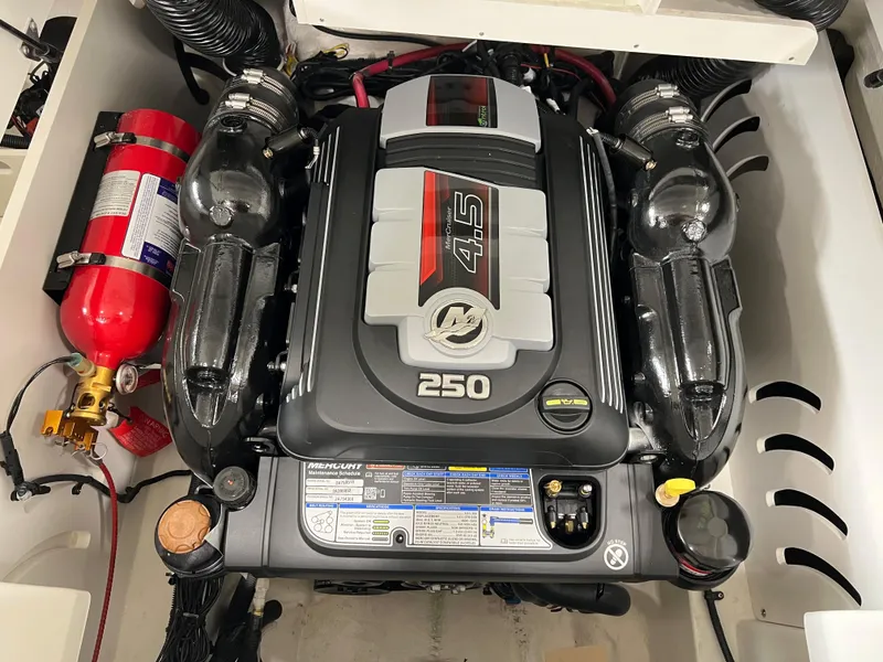 Slide: The Image of 2023 Sea Ray SPX 230 engine compartment with fire extinguisher, featuring a powerful 250 horsepower engine. - 10