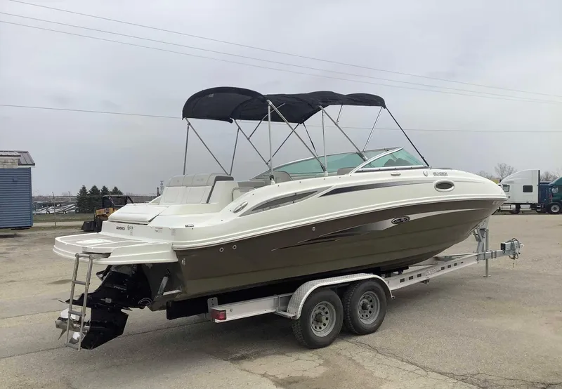 The Image of 2012 Sea Ray 26 Bow Rider boat on a trailer with black canopy. - 1