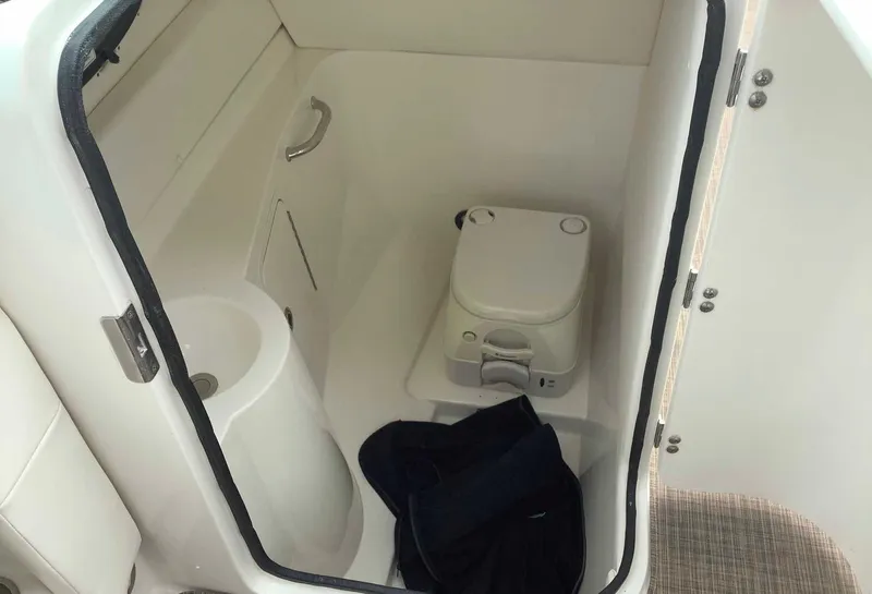 Slide: The Image of 2012 Sea Ray 26 Bow Rider boat interior with compact toilet and sink. - 5