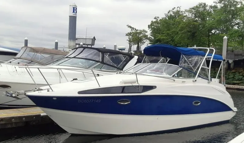 The Image of 2007 Bayliner 265 boat docked at marina with blue and white exterior. - 0