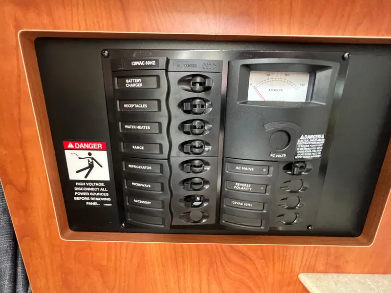 Slide: The Image of Electrical control panel of a 2007 Bayliner 265 boat with various switches and a voltage meter. - 16