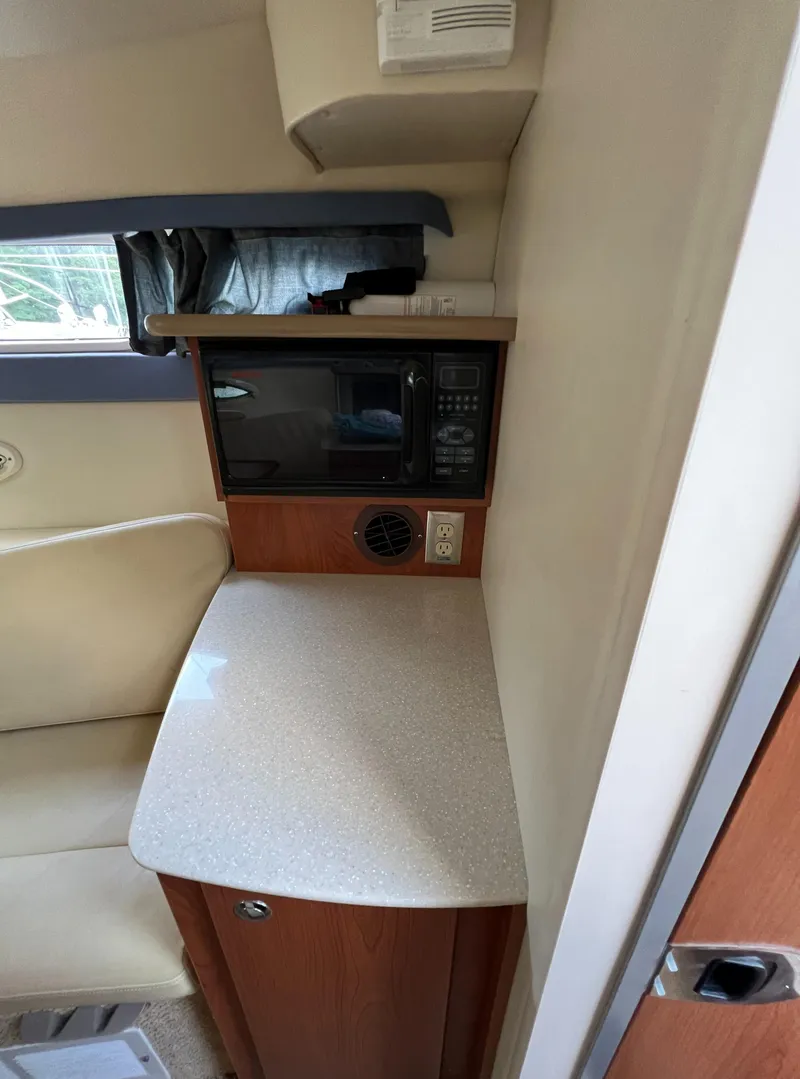 Slide: The Image of 2007 Bayliner 265 interior kitchenette with microwave and counter space. - 17