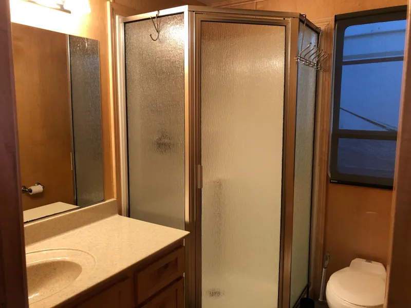 Slide: The Image of Compact RV bathroom with shower, sink, and toilet in a 2005 Custom Entourage Shares model. - 16