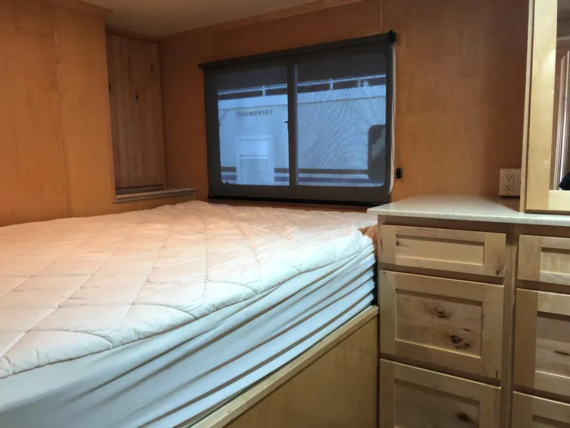 Slide: The Image of Custom 2005 RV interior with bed, window, and wooden cabinets. - 18