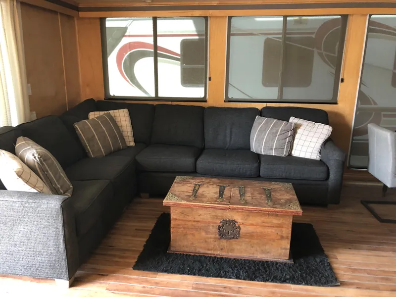 Slide: The Image of Cozy RV interior with sectional sofa, wooden chest coffee table, and decorative pillows. - 19
