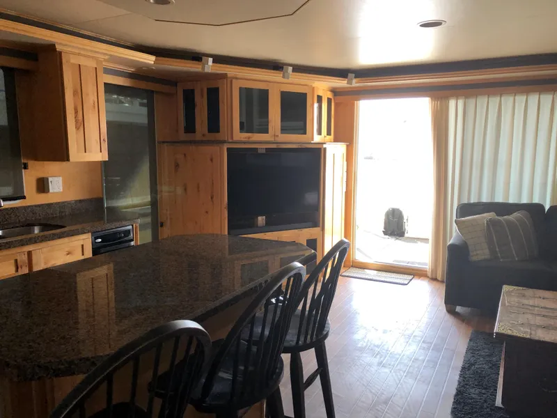 Slide: The Image of Modern RV interior with kitchen island, wooden cabinets, and cozy living area. Custom model, The Entourage Shares #21,33,40,  - 22