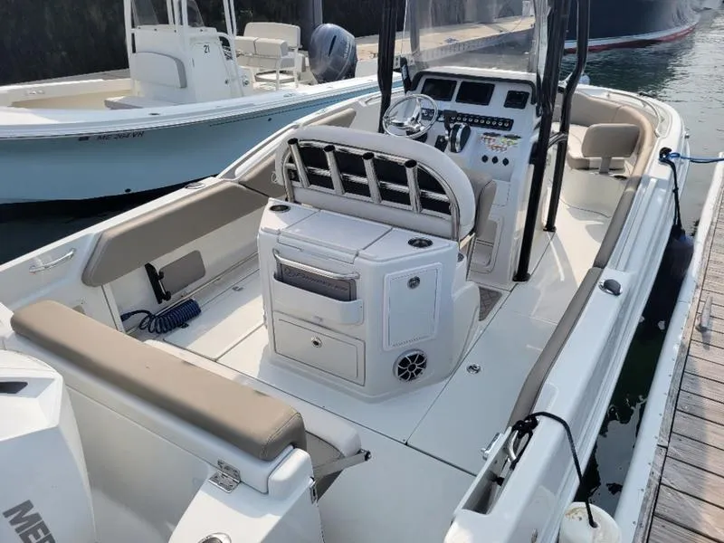 Slide: The Image of 2023 Finseeker 220 boat interior with modern console and seating at dock. - 10