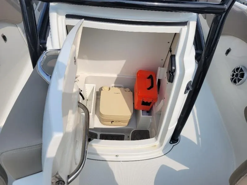 Slide: The Image of 2023 Finseeker 220 boat storage compartment with portable toilet and safety equipment. - 17