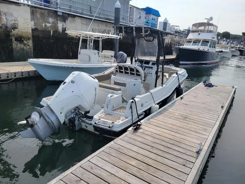 Slide: The Image of 2023 Finseeker 220 boat docked in a marina, featuring a powerful outboard motor. - 8