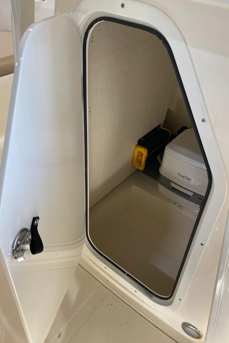 Slide: The Image of 2024 Scout 195 Sportfish storage compartment with portable toilet. - 4
