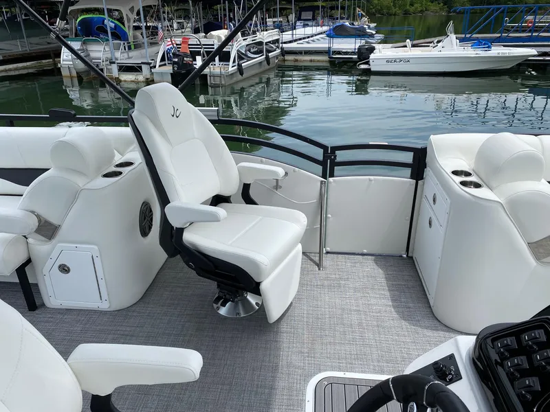 Slide: The Image of 2024 JC Neptoon Sport 23TT DSL pontoon boat interior with white captain's chair and console. - 11