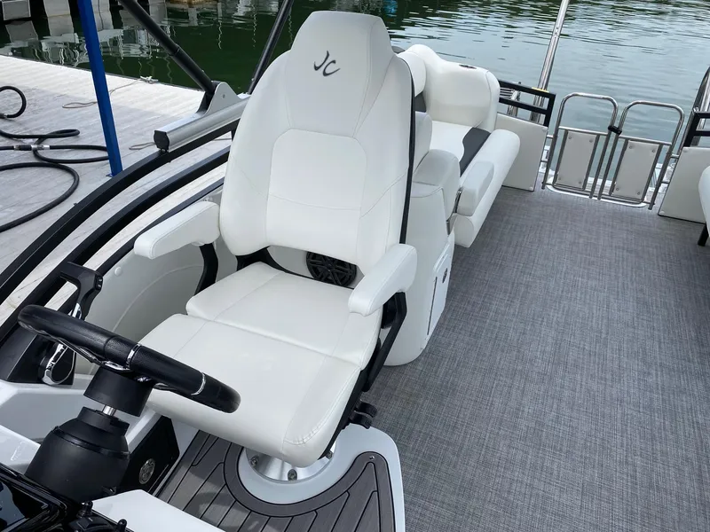 Slide: The Image of 2024 JC Neptoon Sport 23TT DSL boat interior with white captain's chair and steering wheel. - 13