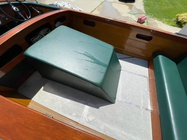 Slide: The Image of 1949 Hacker-Craft Utility boat interior with green leather seating and wooden finish. - 6