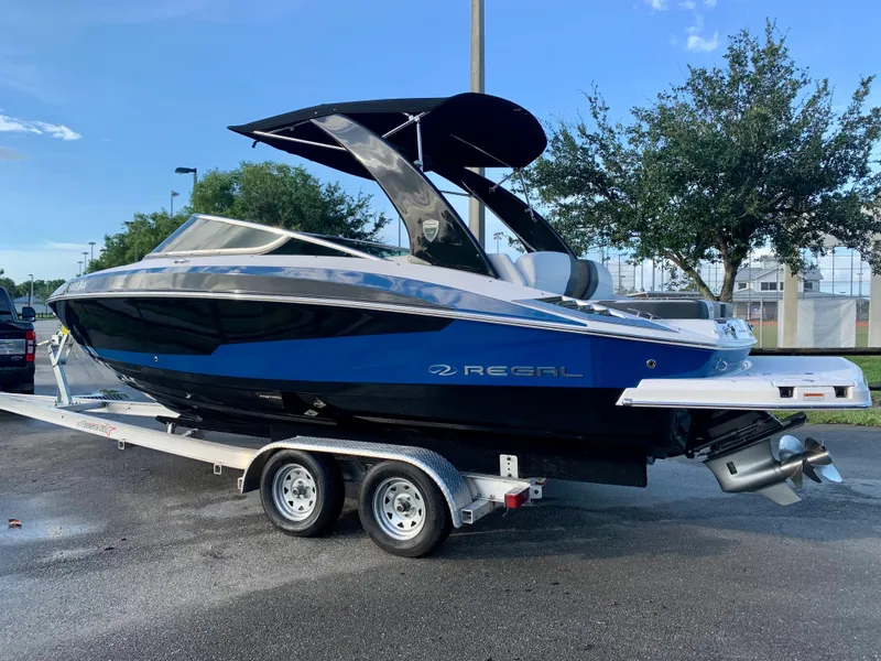 Slide: The Image of 2016 Regal Fastrac boat on a trailer, blue and black exterior, parked outdoors. - 16