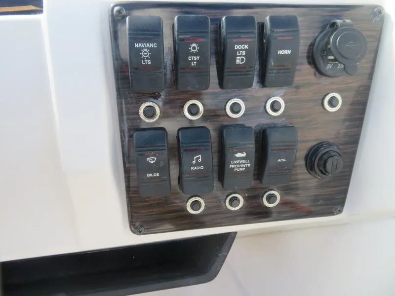 Slide: The Image of Control panel of a 2023 Starcraft SVX OB 231 OB boat with various switches. - 13