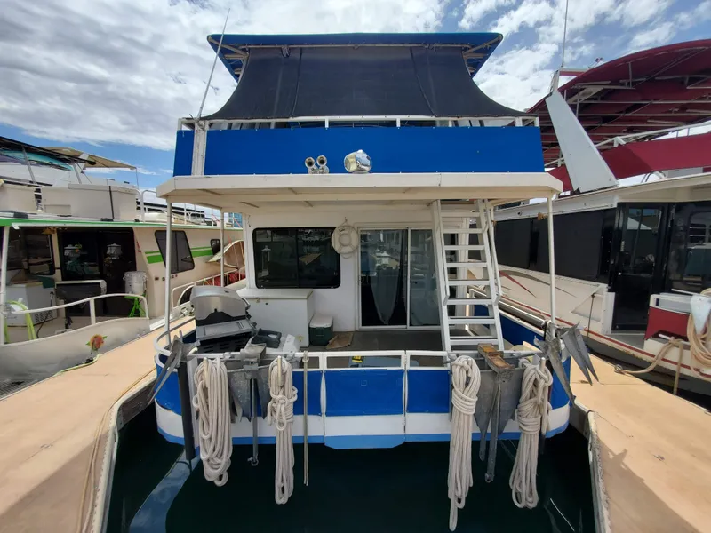 Slide: The Image of 1995 Skipperliner 55x15 Houseboat docked, rear view with ropes and ladder. - 1