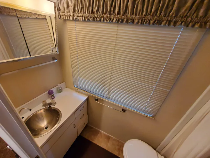 Slide: The Image of Bathroom interior of a 1995 Skipperliner 55x15 Houseboat with sink and window blinds. - 13