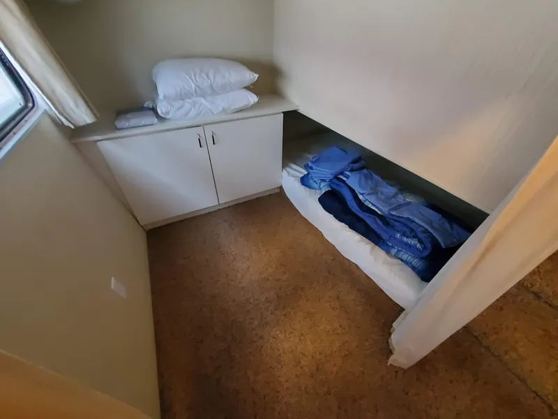 Slide: The Image of 1995 Skipperliner 55x15 Houseboat interior cabin with bed and storage cabinet. - 18