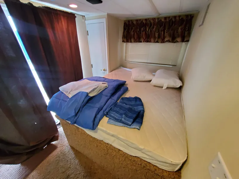 Slide: The Image of 1995 Skipperliner 55x15 Houseboat bedroom with bed, pillows, and folded linens. - 19