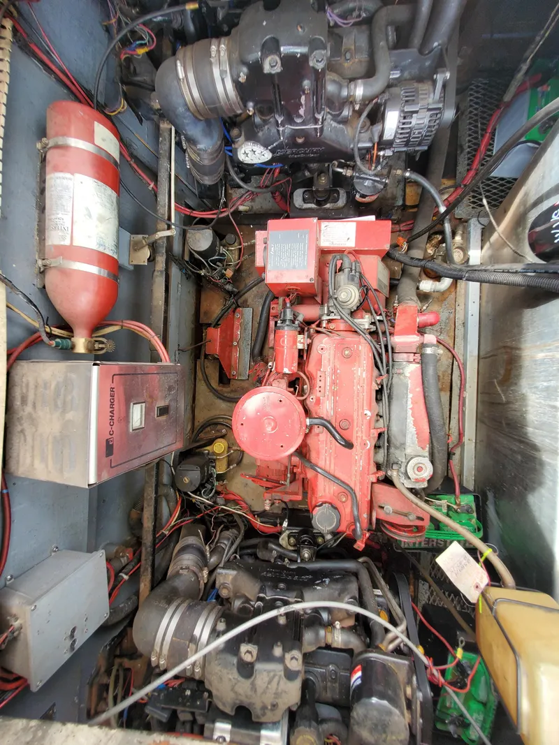 Slide: The Image of Engine room of a 1995 Skipperliner 55x15 Houseboat with visible machinery and fire extinguisher. - 24