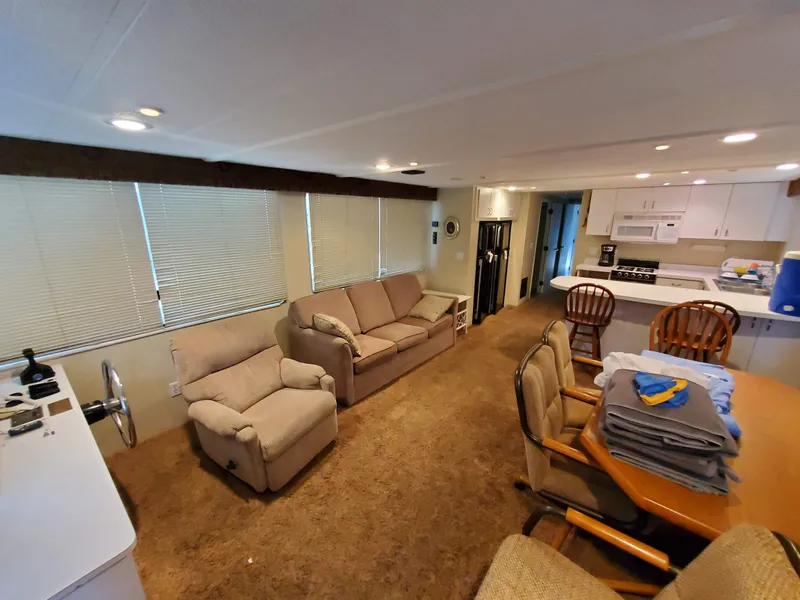 Slide: The Image of Interior of a 1995 Skipperliner 55x15 Houseboat with cozy seating and kitchen area. - 6