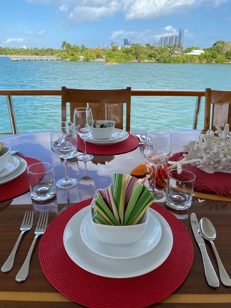 Slide: The Image of Elegant dining setup on 2015 Broward Raised Pilothouse M/Y yacht, overlooking serene waterfront view. - 18
