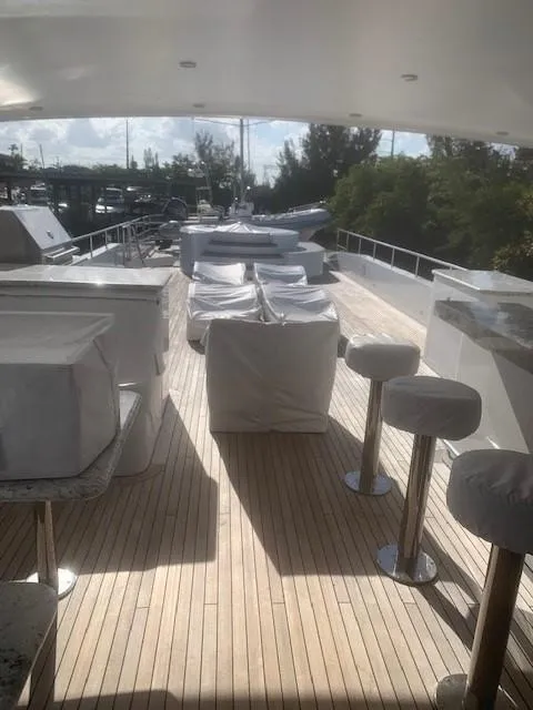 Slide: The Image of Luxurious 2015 Broward Raised Pilothouse M/Y yacht deck with covered seating and bar stools. - 21