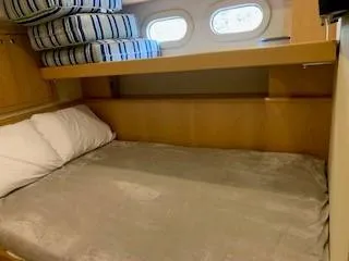Slide: The Image of Cozy cabin bed in 2015 Broward Raised Pilothouse M/Y yacht with porthole windows. - 49
