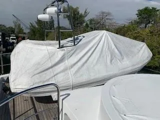 Slide: The Image of 2015 Broward Raised Pilothouse M/Y with covered equipment on deck, surrounded by trees. - 9