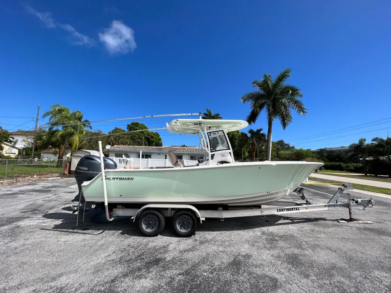 Slide: The Image of 2020 Sportsman Heritage 251 Center Console boat on a trailer, parked outdoors. - 0