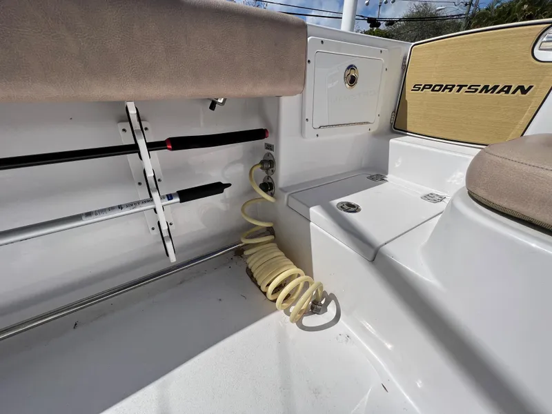 Slide: The Image of 2020 Sportsman Heritage 251 Center Console boat interior with rod holders and coiled hose. - 30
