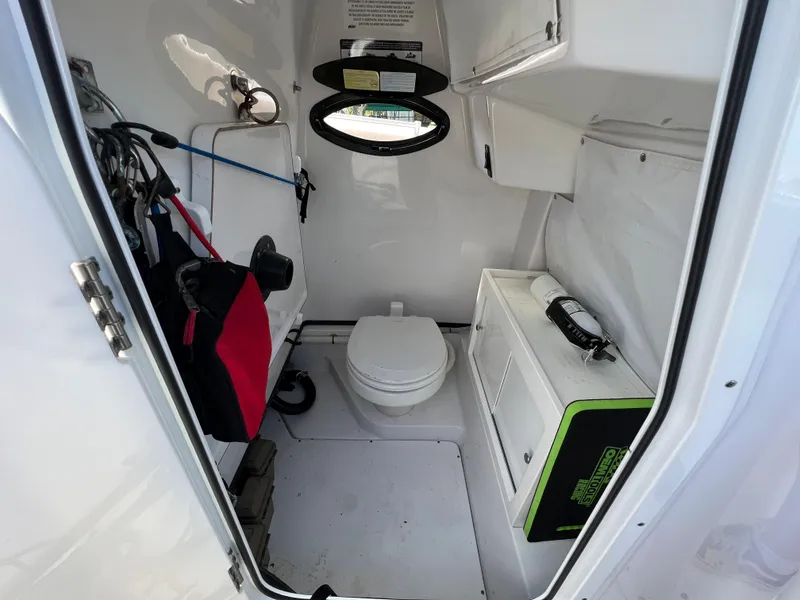 Slide: The Image of 2020 Sportsman Heritage 251 Center Console boat interior with toilet and storage. - 36