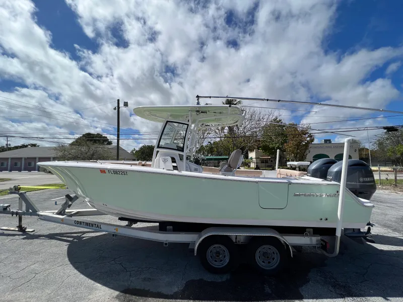 Slide: The Image of 2020 Sportsman Heritage 251 Center Console boat on a trailer under a partly cloudy sky. - 4