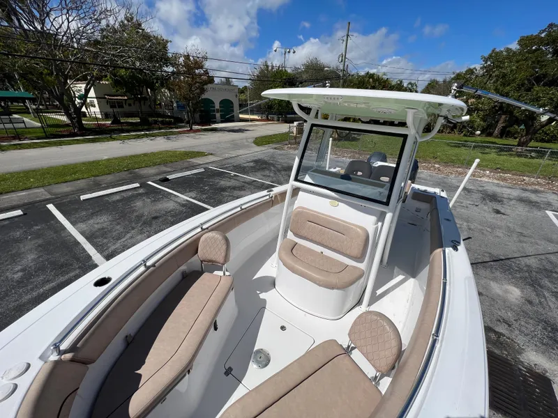 Slide: The Image of 2020 Sportsman Heritage 251 Center Console boat with beige seating in a parking lot. - 43