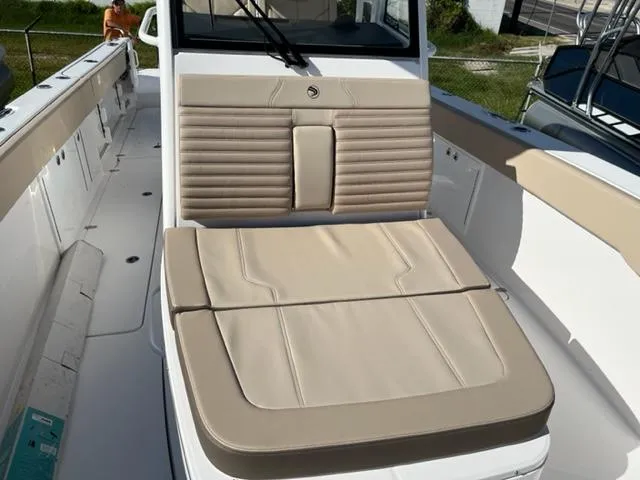 Slide: The Image of 2023 Edgewater 340CC boat interior with beige seating and white deck. - 13