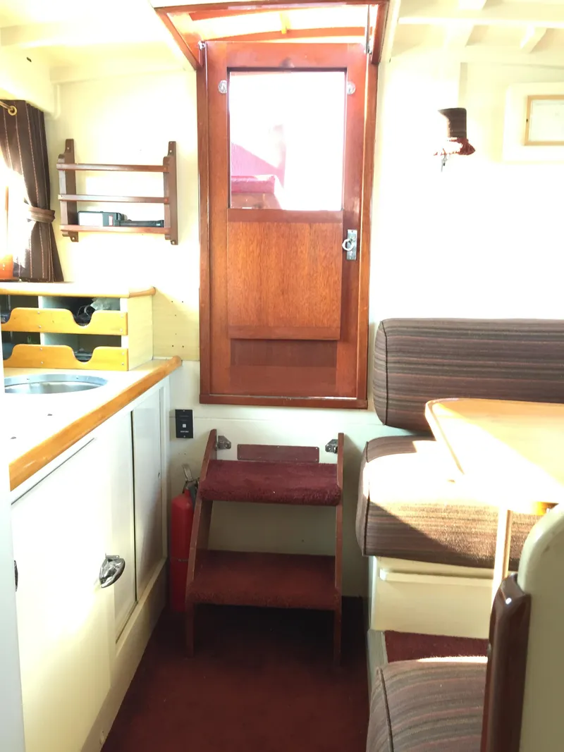 Slide: The Image of 1954 Chris-Craft Commander interior with wooden door, steps, and cozy seating area. - 12