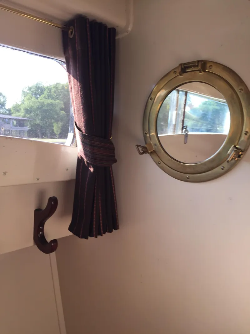 Slide: The Image of 1954 Chris-Craft Commander interior with porthole and window curtain. - 13