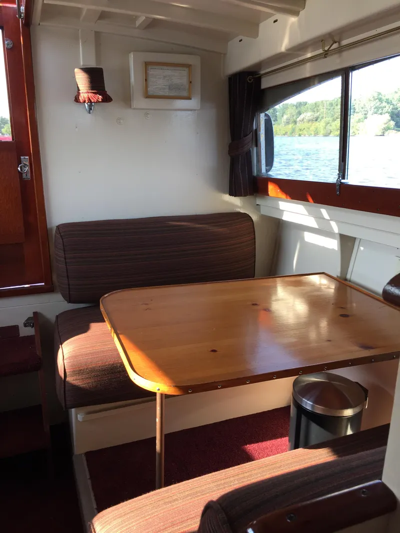 Slide: The Image of 1954 Chris-Craft Commander interior with wooden table, cushioned seating, and window view. - 18