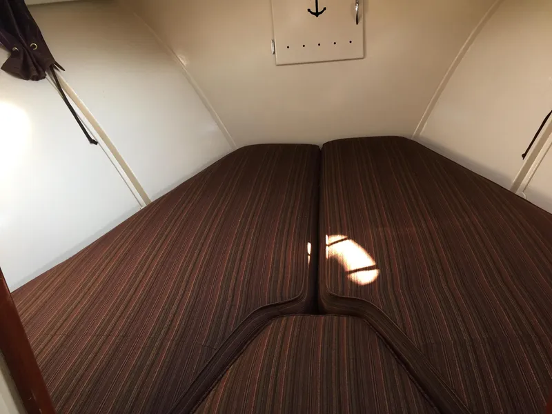 Slide: The Image of 1954 Chris-Craft Commander cabin interior with striped bedding and white walls. - 20