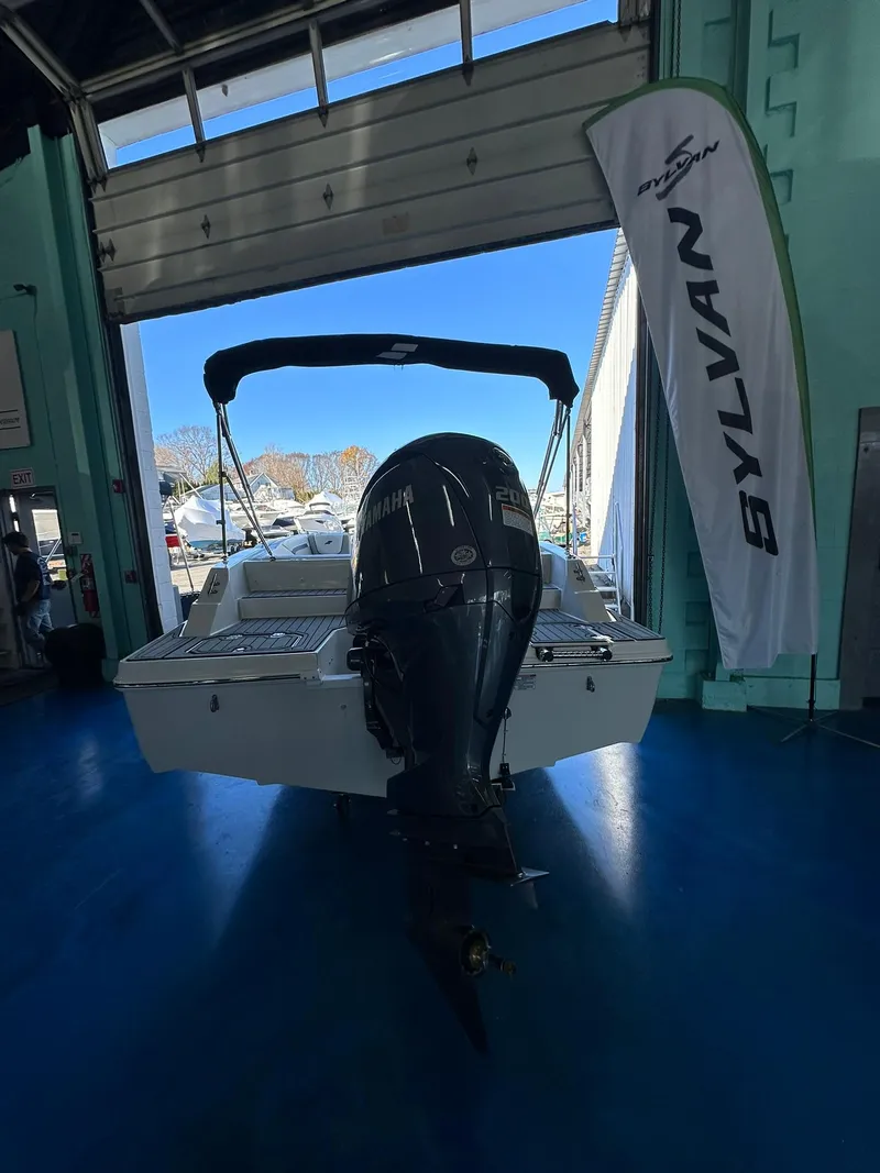 Slide: The Image of 2025 Starcraft SVX 211 OB boat in a showroom, white exterior, sleek design. - 4