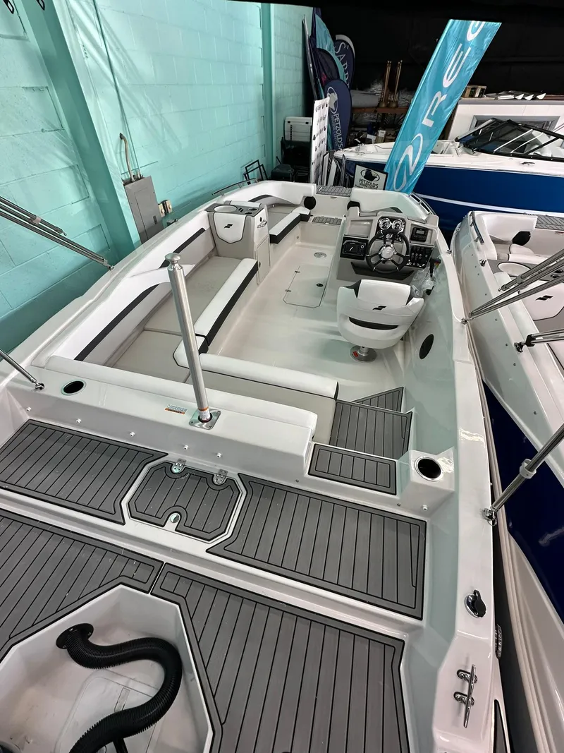 Slide: The Image of 2025 Starcraft SVX 211 OB boat in showroom with Sylvan banner. - 6