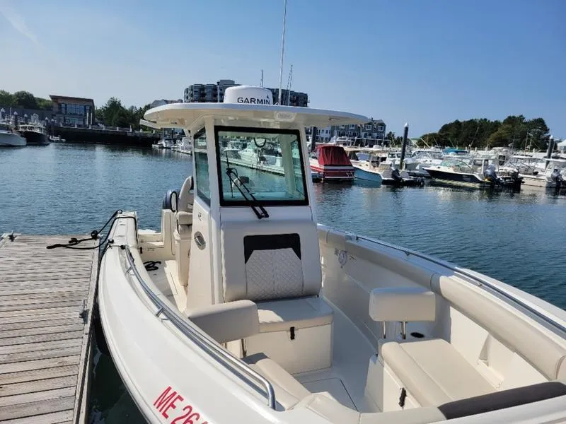 Slide: The Image of 2023 Sailfish 272 CC boat docked in a marina under clear blue skies. - 11