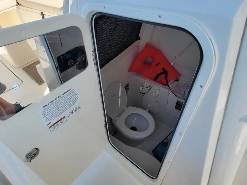 Slide: The Image of 2023 Sailfish 272 CC boat interior with toilet and life jacket. - 12
