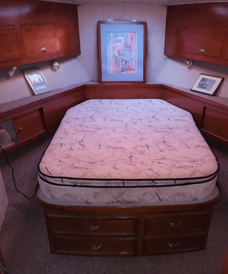 Slide: The Image of 1983 Ocean Yachts Super Sport bedroom with wooden cabinets and framed artwork. - 12