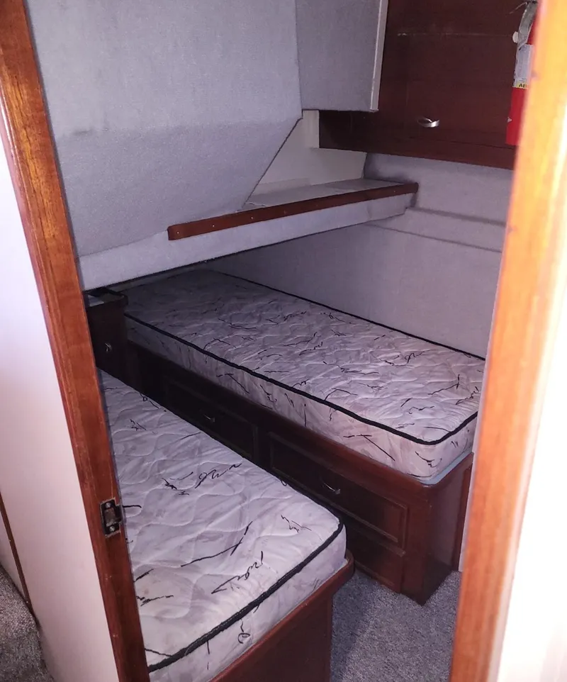 Slide: The Image of 1983 Ocean Yachts Super Sport cabin with twin beds and wooden storage. - 13