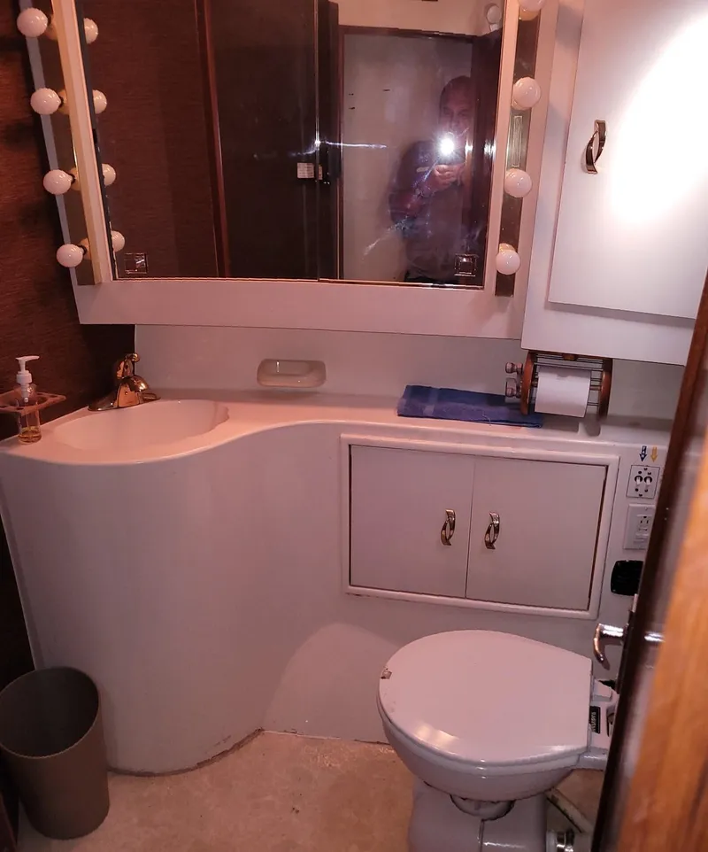 Slide: The Image of 1983 Ocean Yachts Super Sport bathroom with vanity, mirror, and toilet. - 15