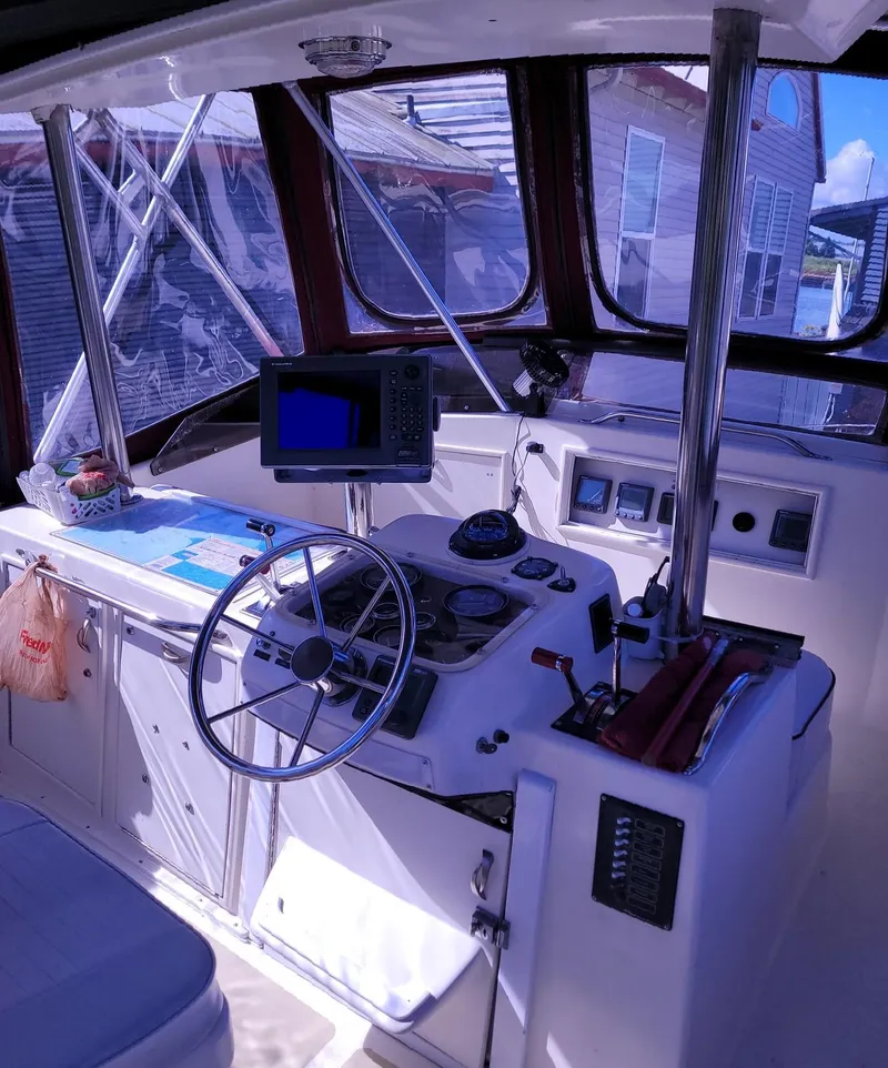 Slide: The Image of 1983 Ocean Yachts Super Sport boat cockpit with steering wheel and navigation equipment. - 18