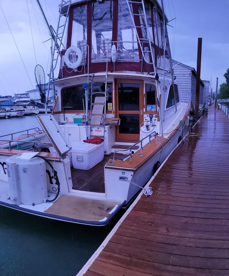 Slide: The Image of 1983 Ocean Yachts Super Sport docked at a marina on a rainy day. - 2